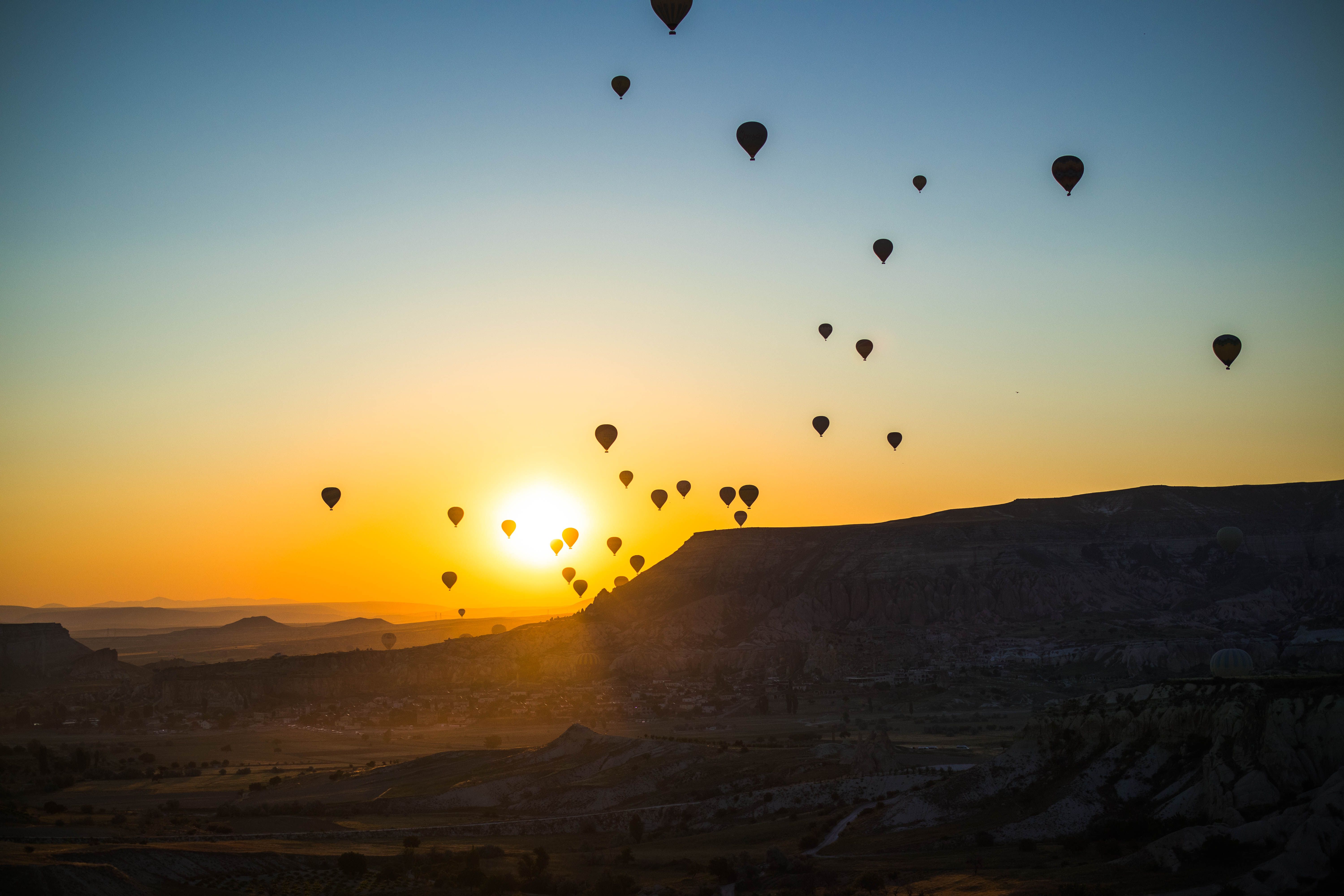 Hot air balloons soaring over the Cappadocia landscape during a breathtaking sunrise