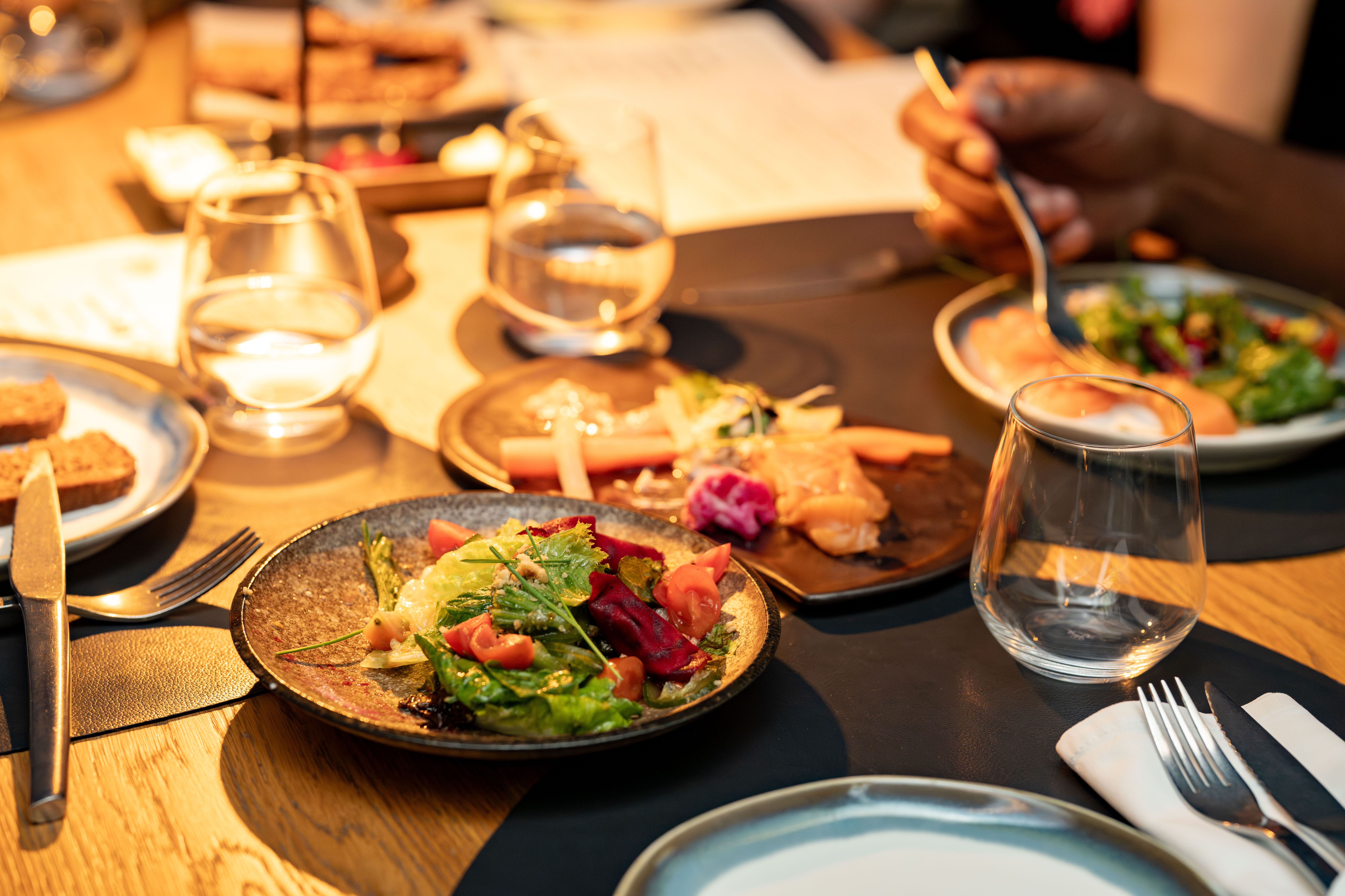 A beautifully set gourmet dinner table with wine glasses for a classy dining experience