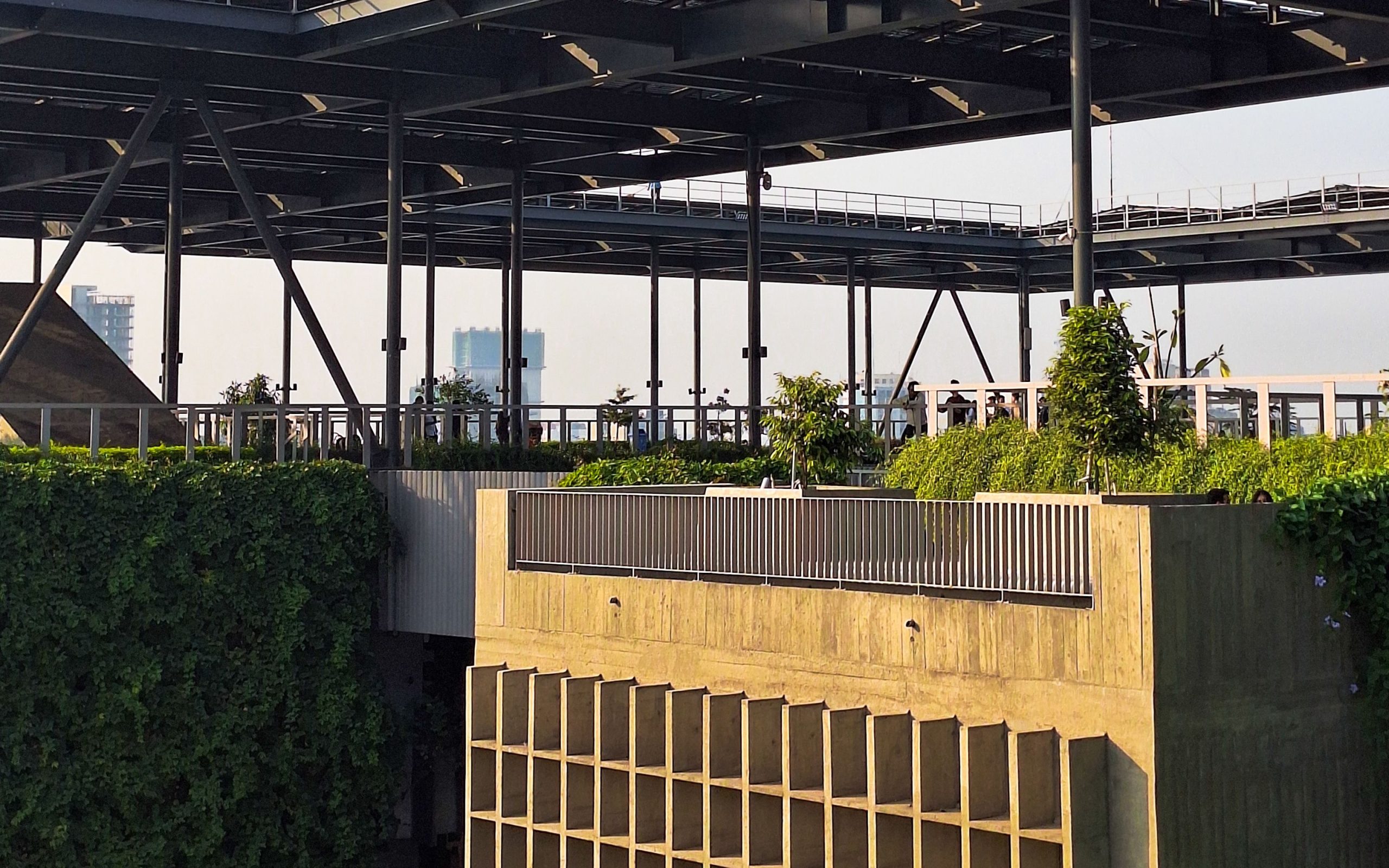 A rooftop garden integrated with a modern steel-and-concrete structure, showing how durable architectural materials can frame urban greenery.